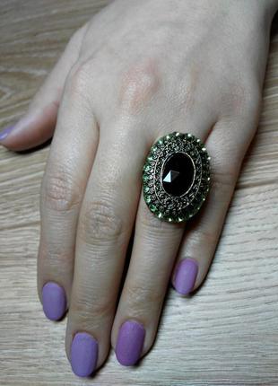 Крупный перстень с центральным черным камнем и светло зеленень...