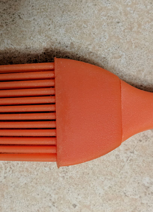 Новая оранжевая кухонная силиконовая кисточка.