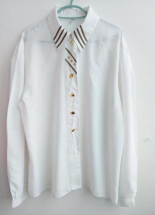 Нарядная белая блуза с золотыми пуговицами и широкими рукавами...
