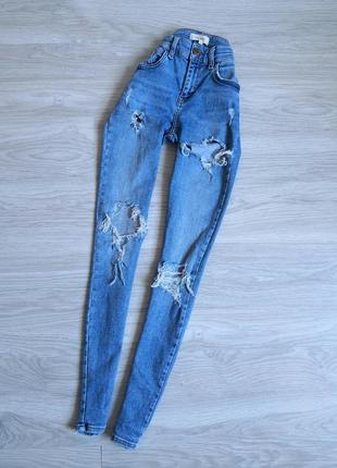 Голубые стрейчевые джинсы с фабричными рваностями