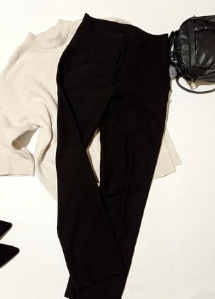 Черные классические брюки с лчень выслкой посадкой на пуговица...