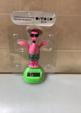 Фламінго рожевий іграшка танцює на сонячній батареї