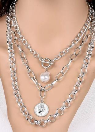 Многослойное ожерелье- цепочка с подвесками в серебряном цвете.