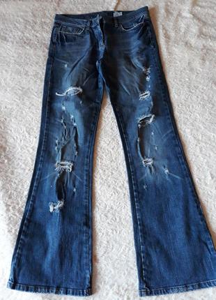 Синие джинсы с рваными коленками