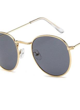 Круглі сонцезахисні окуляри у золотистій оправі з сірою лінзою