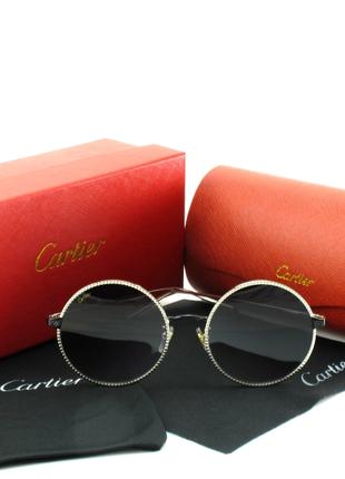 Жіночі круглі сонцезахисні окуляри Cartier в срібних оправах.