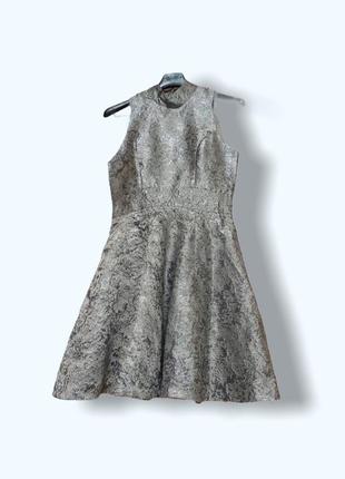 Платье из серебряной парчи с пышной юбкой и вырезом на спине