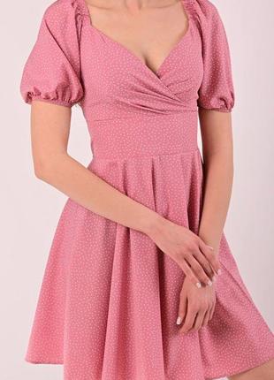 Розовое платье в горошек с декольте