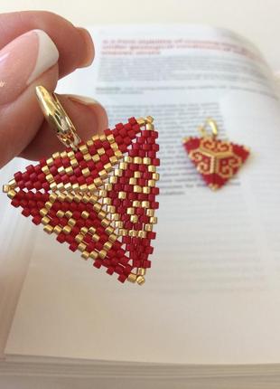 Красные треугольные серьги с золотистым орнаментом