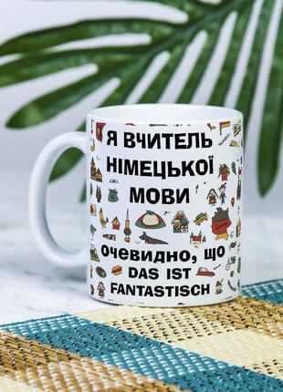 Белая чашка на подарок с надписью "Я учитель немецкого языка, ...
