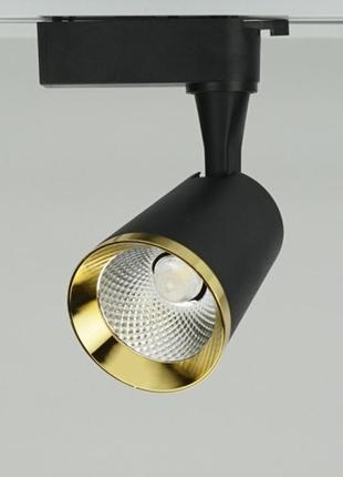 Трековий світильник у чорному корпусі із золотою фурнітурою.