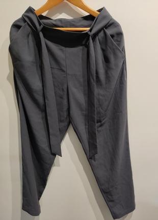 Серые брюки с карманами и поясом на молнии сбоку