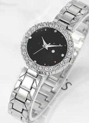 Годинник у срібному кольорі з білими кристалами.