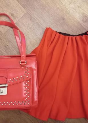Красная лаковая сумка, плюс красная юбка.