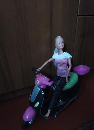 Кукла барби на мотоцикле.