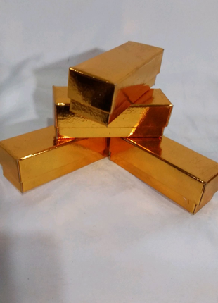 Коробка подарочная, картонная, золотого цвета размером 9/3/3 см.