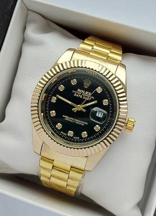 Чоловічий наручний годинник золотого кольору з чорним цифербла...