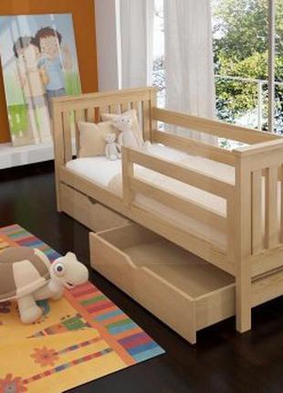 Детская кровать изготовлена из дерева ольхи с ящиками.